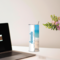Desk scene with tumbler next to laptop and beautiful vase with flowers. Perfect setting for work from home, or anytime
